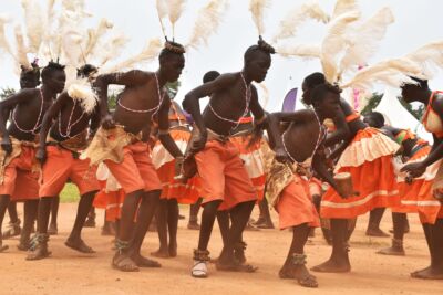 Uganda-tribe Group of ugandan men in traditional orange clothing perform a traditional dance