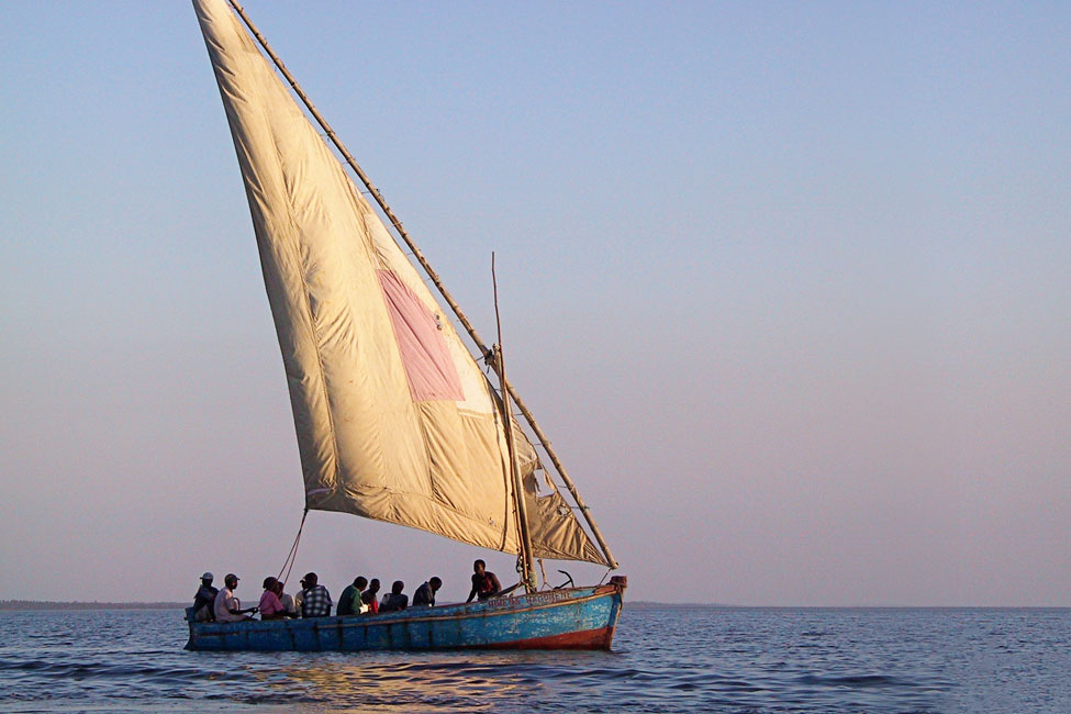 Dhow sailboat with passenggers on open water on coast of Mozambique