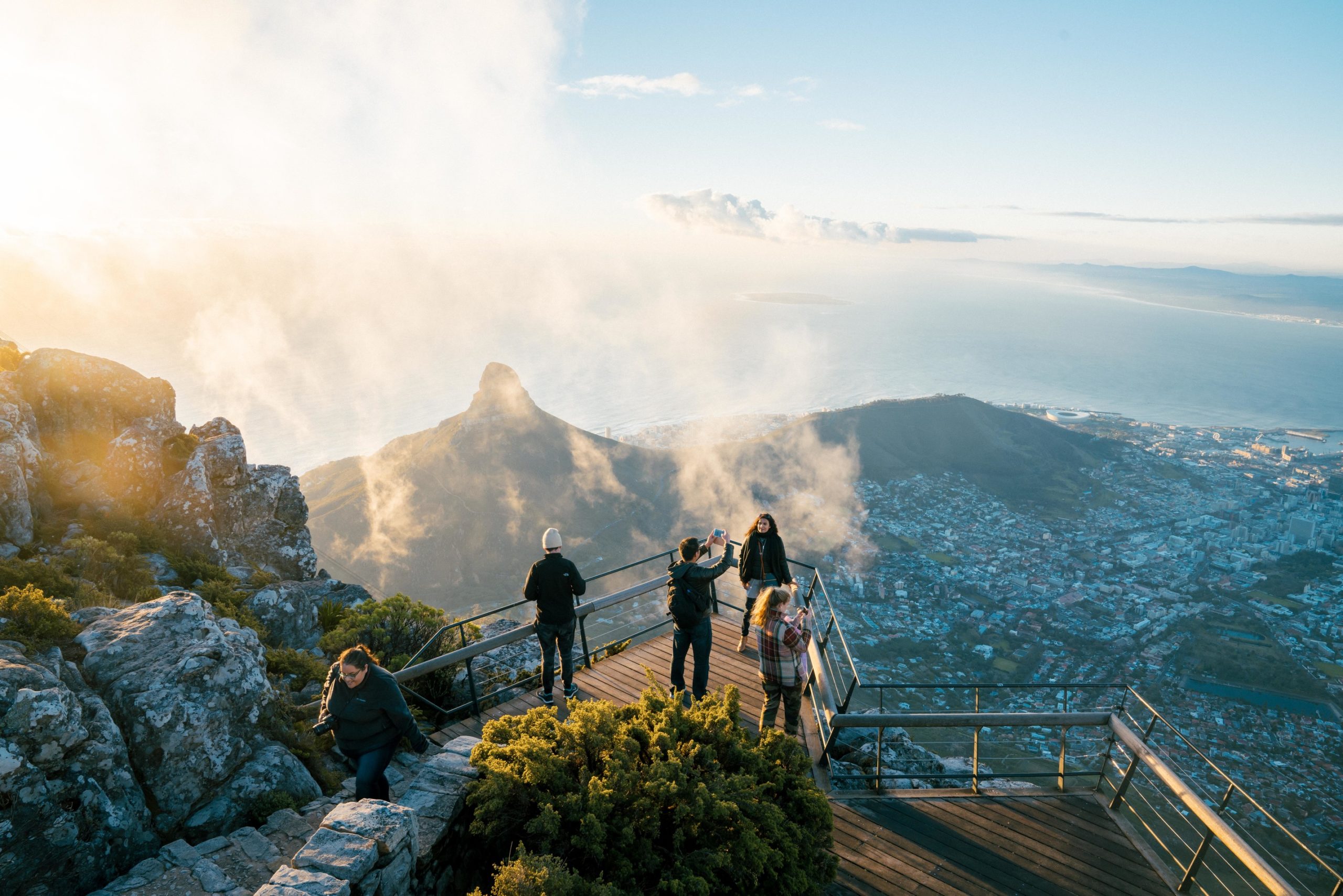 travelers pose for selfies at Table Mountain in Cape Town, South Africa