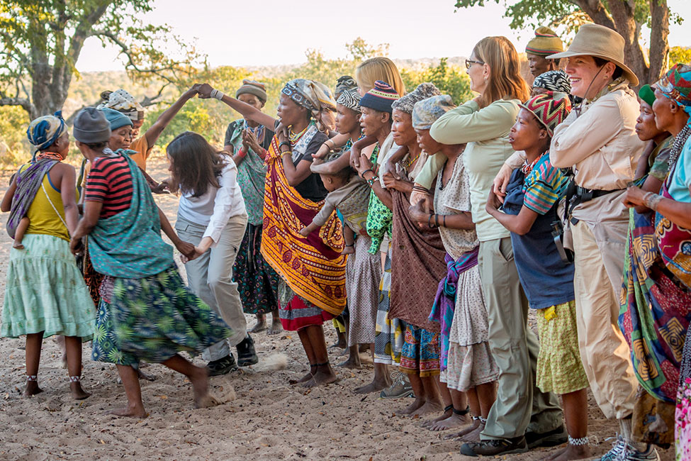people learn a local dance from villagers as one of their safari activities