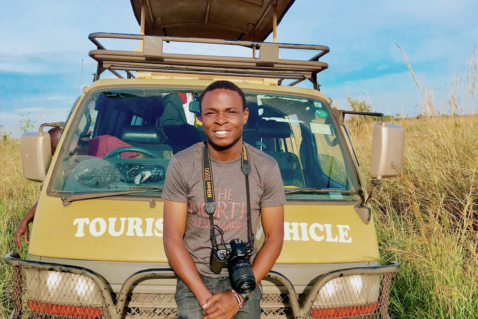 Game Drive Guide stands in front of his safari vehicle