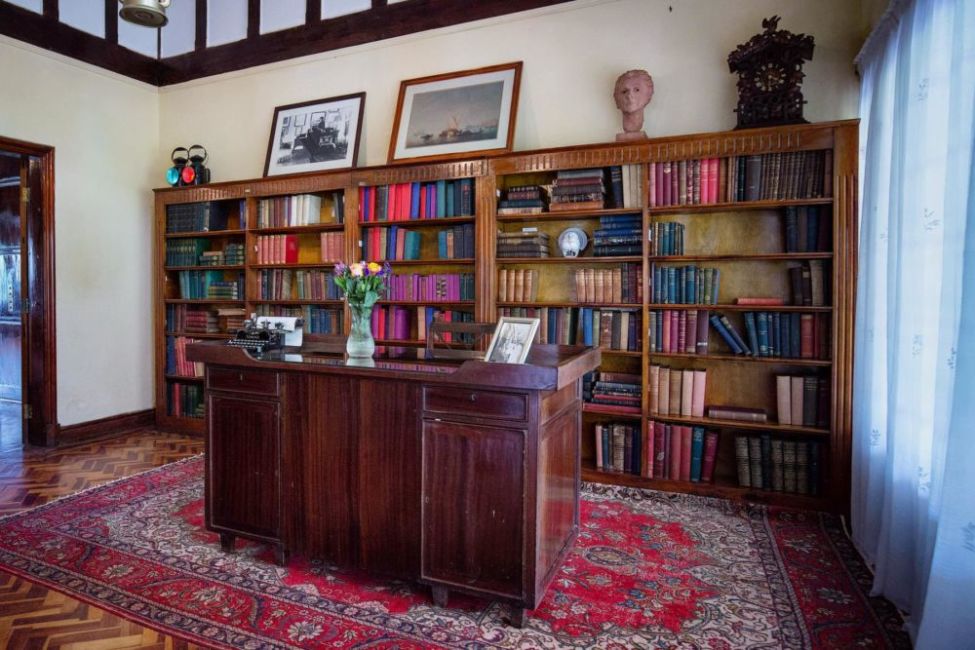 kenya-nairobi-karen-blixen-museum-Stuart-Price-Make-It-Kenya-flickr Karen Blixen's library is an early 20th century study with wall-to-wall wooden bookshelf filled with books and a wooden desk with mechanical typewriter