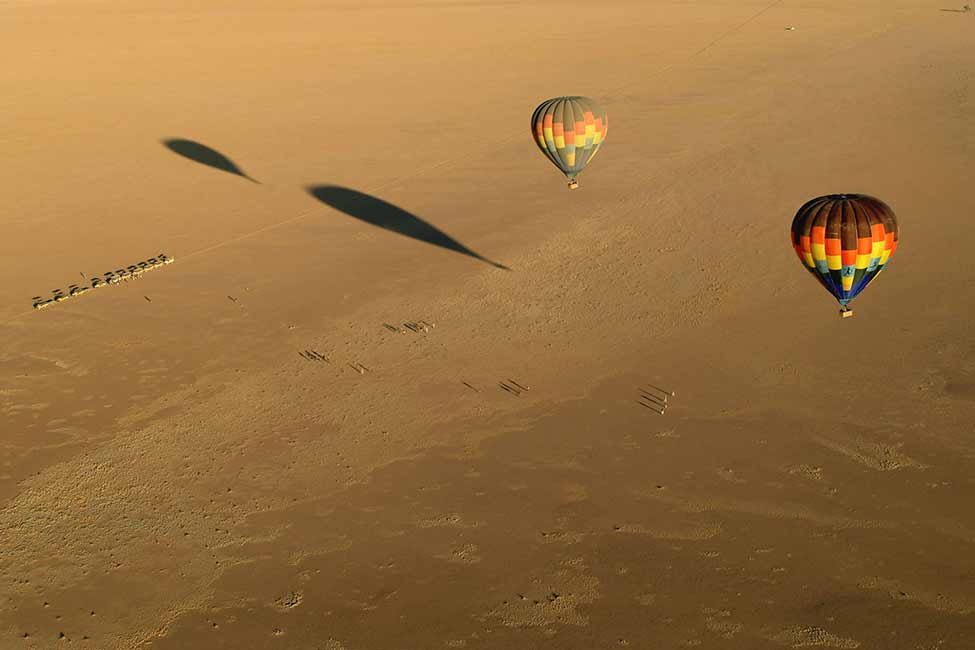 a pair of hot air balloons float in Namibia Africa