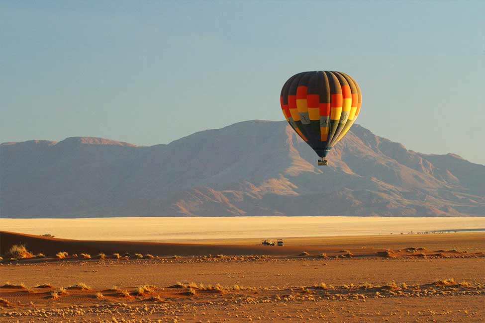a hot air balloon floats over sossusvlei in Namibia Africa