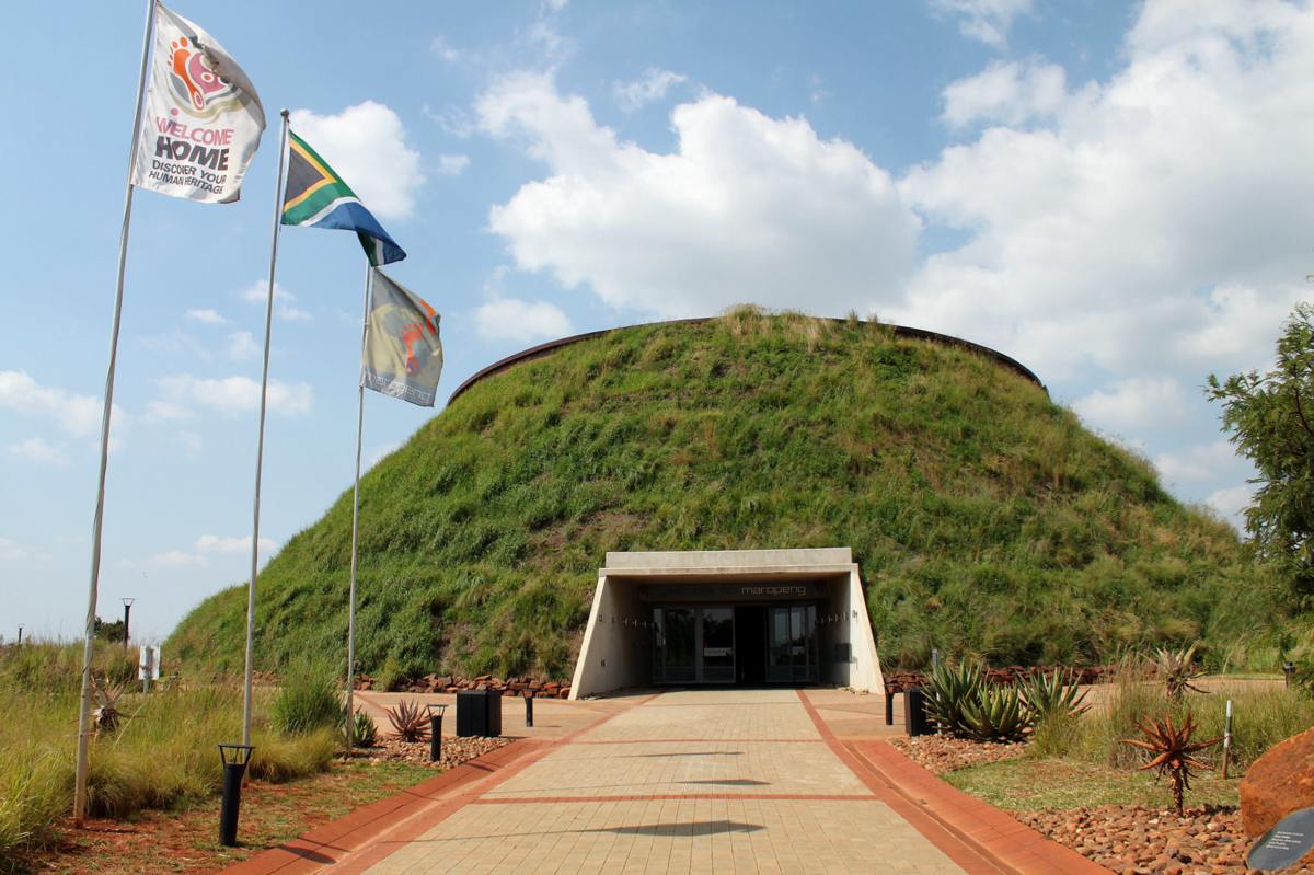 brick walkway leading up to Maropeng Visitors Center a modern mound building with grass roof at the cradle of humankind in South Africa