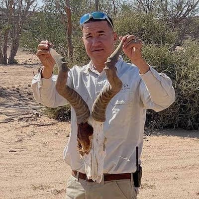 Namibian safari guide holds up an antelope skull found in the desert