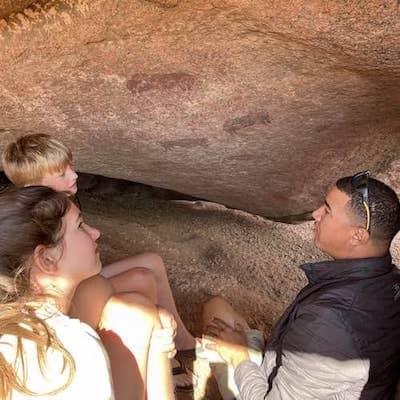namibian safari guide shows prehistoric rock art at twyfelfontein namibia to two children