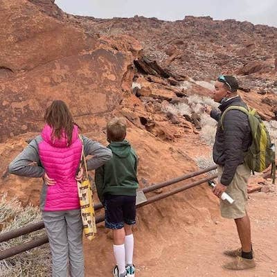 namibian safari guide shows prehistoric rock art at twyfelfontein namibia to two children