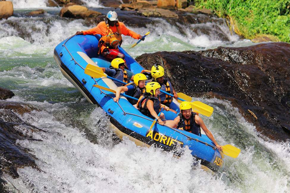 a guide and vacationers paddle down a rapid in Jinja Uganda, which offers many active things to do on safari